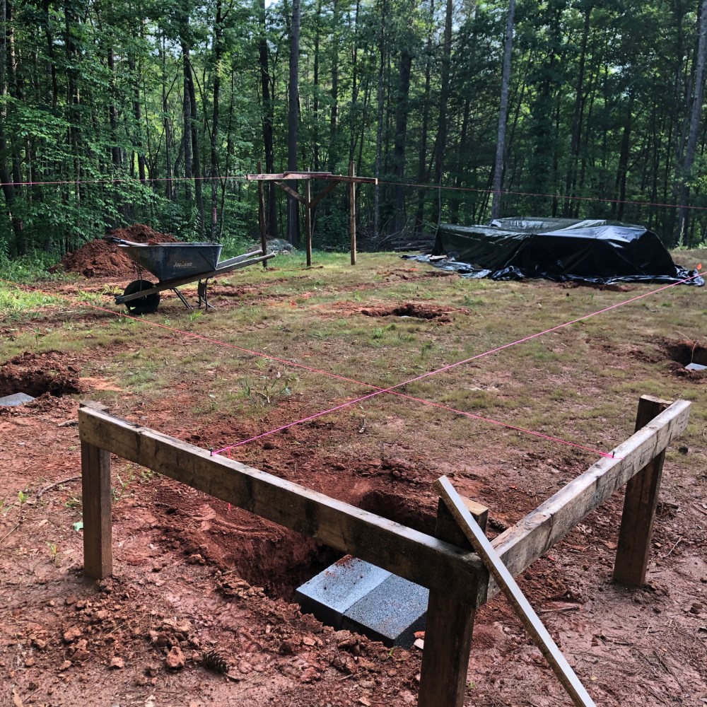 Wooden scaffolding with pier holes and concrete blocks.